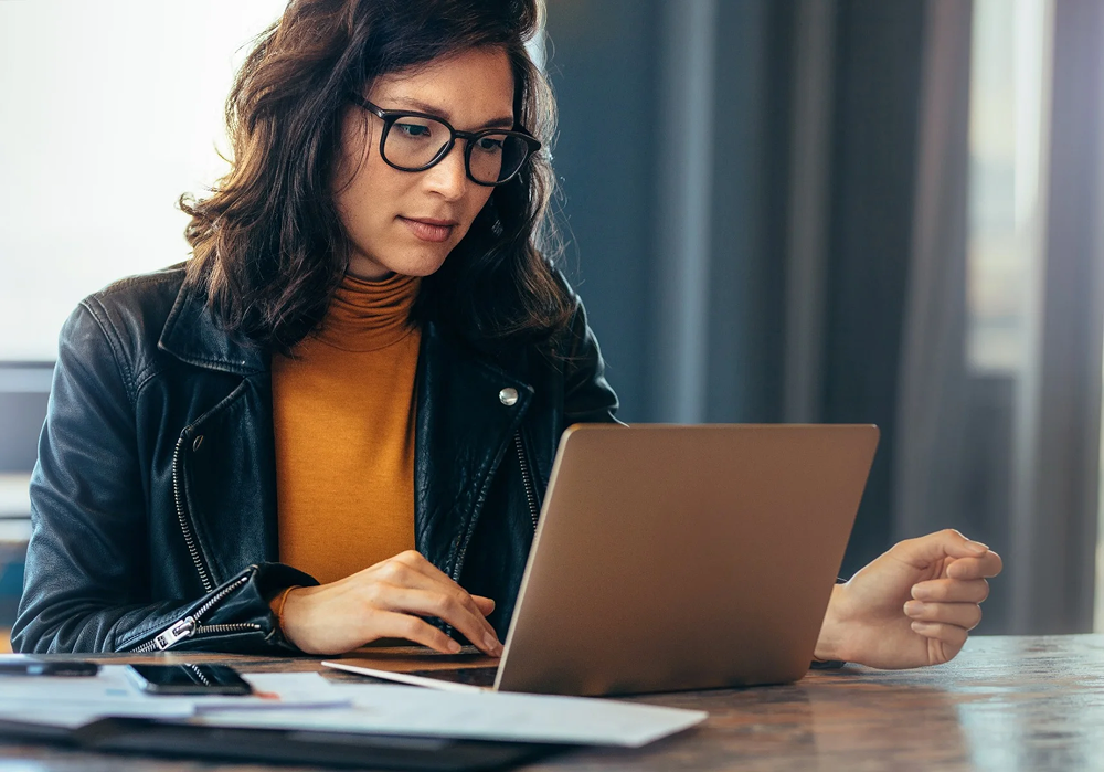 Professional working at computer desk with occupational lenses, showing comfortable vision for office work